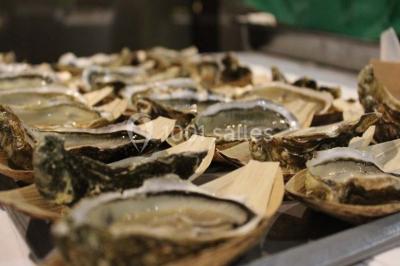 Chambre moderne avec lit double, bureau équipé, grande fenêtre avec vue sur les toits et éclairage suspendu.