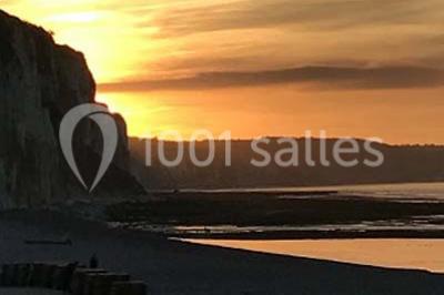 Chambre moderne avec lit double, bureau équipé, grande fenêtre avec vue sur les toits et éclairage suspendu.
