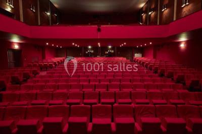 Chambre moderne avec lit double, bureau équipé, grande fenêtre avec vue sur les toits et éclairage suspendu.
