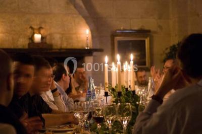 Chambre lumineuse avec lit double, deux tables de chevet, lampes murales, fauteuil et rideaux à motifs floraux.
