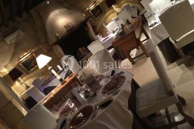 Chambre lumineuse avec lit double, deux tables de chevet, lampes murales, fauteuil et rideaux à motifs floraux.