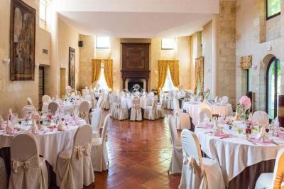Chambre lumineuse avec lit double, deux tables de chevet, lampes murales, fauteuil et rideaux à motifs floraux.