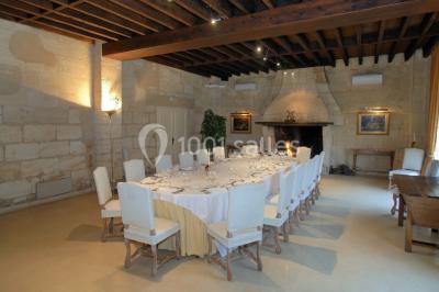 Chambre lumineuse avec lit double, deux tables de chevet, lampes murales, fauteuil et rideaux à motifs floraux.