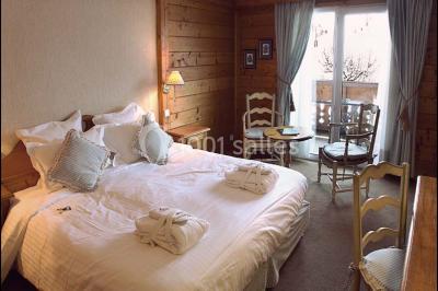 Chalet en bois éclairé de nuit avec balcons, toit enneigé et enseigne ’La Tapiaz’.