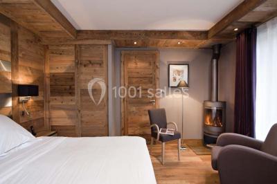 Chalet en bois éclairé de nuit avec balcons, toit enneigé et enseigne ’La Tapiaz’.