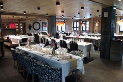 Chalet en bois éclairé de nuit avec balcons, toit enneigé et enseigne ’La Tapiaz’.