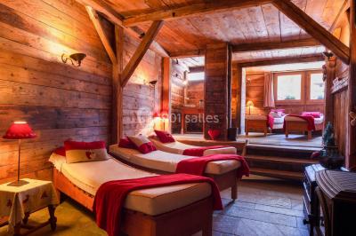 Chalet en bois éclairé de nuit avec balcons, toit enneigé et enseigne ’La Tapiaz’.