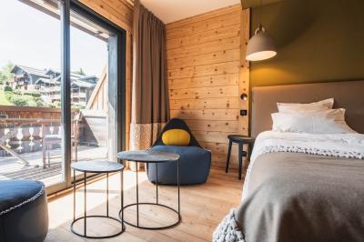 Chalet en bois éclairé de nuit avec balcons, toit enneigé et enseigne ’La Tapiaz’.