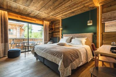 Chalet en bois éclairé de nuit avec balcons, toit enneigé et enseigne ’La Tapiaz’.