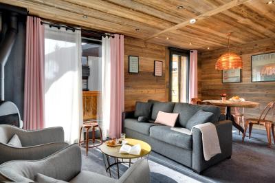 Chalet en bois éclairé de nuit avec balcons, toit enneigé et enseigne ’La Tapiaz’.