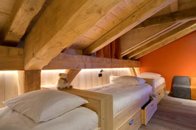 Chalet en bois éclairé de nuit avec balcons, toit enneigé et enseigne ’La Tapiaz’.