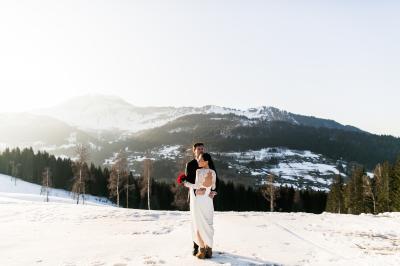 Chalet en bois éclairé de nuit avec balcons, toit enneigé et enseigne ’La Tapiaz’.
