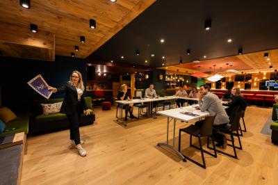 Une réunion d'équipe se déroule dans une salle moderne avec écran de présentation et éclairage design.