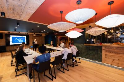 Une réunion d'équipe se déroule dans une salle moderne avec écran de présentation et éclairage design.