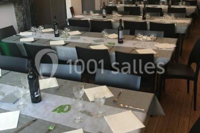 Grande maison en briques rouges avec deux tours, entourée de pelouse et de voitures garées devant.