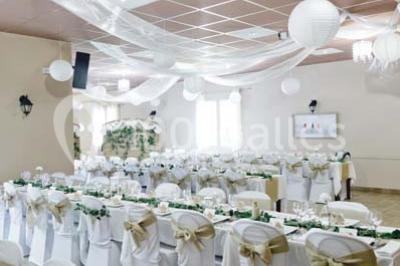 Une mariée en robe blanche est assise sur un banc en bois décoré des lettres ’A&J’, tenant un bouquet de fleurs.