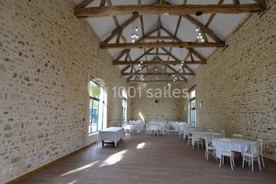 Vue aérienne d'un jardin arboré avec des allées herbeuses, entouré de champs et de quelques bâtiments résidentiels.