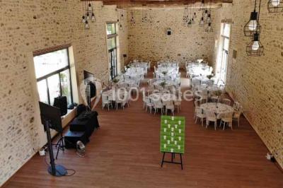 Vue aérienne d'un jardin arboré avec des allées herbeuses, entouré de champs et de quelques bâtiments résidentiels.