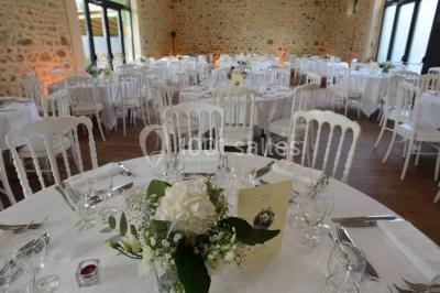 Vue aérienne d'un jardin arboré avec des allées herbeuses, entouré de champs et de quelques bâtiments résidentiels.