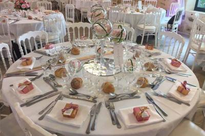 Vue aérienne d'un jardin arboré avec des allées herbeuses, entouré de champs et de quelques bâtiments résidentiels.