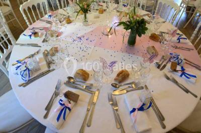 Vue aérienne d'un jardin arboré avec des allées herbeuses, entouré de champs et de quelques bâtiments résidentiels.
