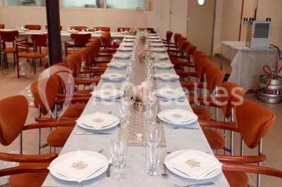 Évier double en inox avec robinet flexible, lave-vaisselle professionnel et sol en carrelage beige dans une cuisine.