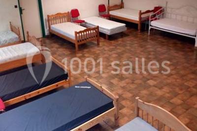 Évier double en inox avec robinet flexible, lave-vaisselle professionnel et sol en carrelage beige dans une cuisine.