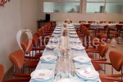 Évier double en inox avec robinet flexible, lave-vaisselle professionnel et sol en carrelage beige dans une cuisine.