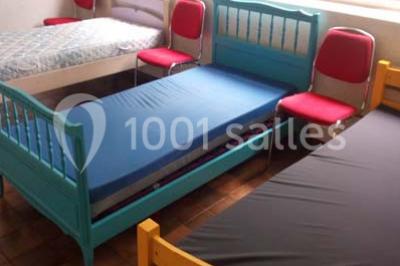 Évier double en inox avec robinet flexible, lave-vaisselle professionnel et sol en carrelage beige dans une cuisine.