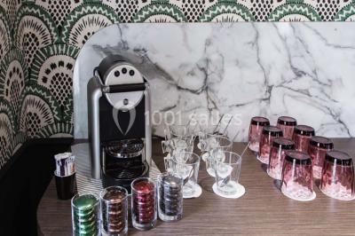 Une femme présente des informations sur un écran à trois personnes assises dans une salle de réunion décorée.