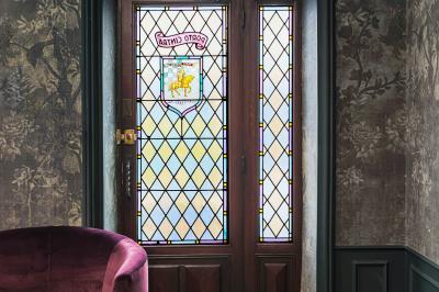 Une femme présente des informations sur un écran à trois personnes assises dans une salle de réunion décorée.