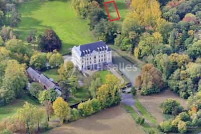 Salon lumineux avec parquet, mobilier classique, table ronde dressée au centre et lustre en cristal au plafond.