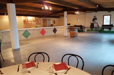 Chemin en gravier bordé de barrières en bois, entouré d'arbres et d'herbe sous un ciel dégagé.