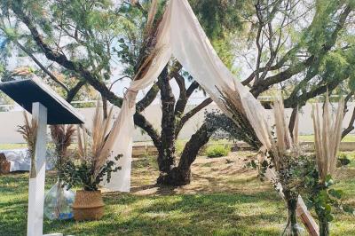 Chemin en gravier bordé de barrières en bois, entouré d'arbres et d'herbe sous un ciel dégagé.