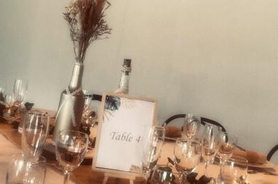 Chemin en gravier bordé de barrières en bois, entouré d'arbres et d'herbe sous un ciel dégagé.