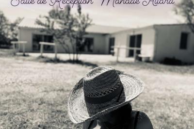 Chemin en gravier bordé de barrières en bois, entouré d'arbres et d'herbe sous un ciel dégagé.