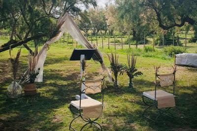 Chemin en gravier bordé de barrières en bois, entouré d'arbres et d'herbe sous un ciel dégagé.