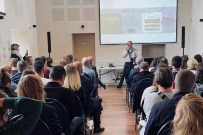 Cabane en bois perchée dans les arbres, entourée de forêt et bordée d'une prairie verdoyante.