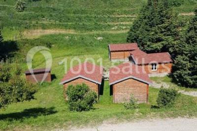 Tables hautes recouvertes de nappes blanches, décorées de bouquets, dans une salle lumineuse avec baies vitrées.