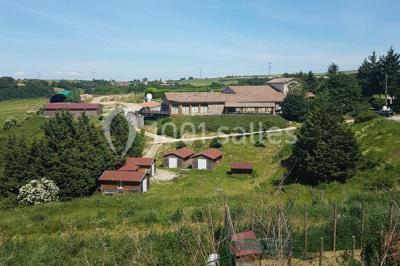 Tables hautes recouvertes de nappes blanches, décorées de bouquets, dans une salle lumineuse avec baies vitrées.