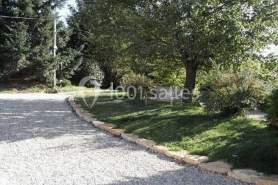 Tables hautes recouvertes de nappes blanches, décorées de bouquets, dans une salle lumineuse avec baies vitrées.
