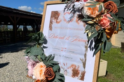 Tables hautes recouvertes de nappes blanches, décorées de bouquets, dans une salle lumineuse avec baies vitrées.