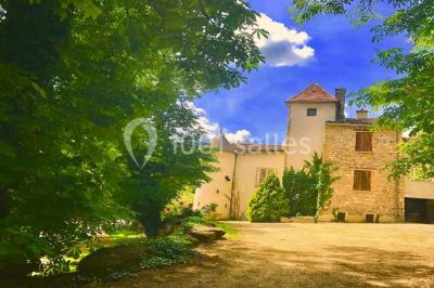 Parking extérieur de nuit, éclairé par des lumières jaunes et entouré d'arbres et de bâtiments.