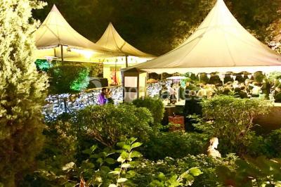 Parking extérieur de nuit, éclairé par des lumières jaunes et entouré d'arbres et de bâtiments.