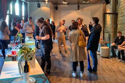Parking extérieur de nuit, éclairé par des lumières jaunes et entouré d'arbres et de bâtiments.