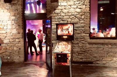 Parking extérieur de nuit, éclairé par des lumières jaunes et entouré d'arbres et de bâtiments.