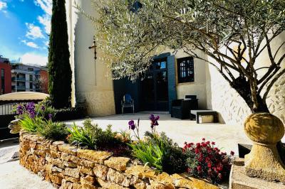 Parking extérieur de nuit, éclairé par des lumières jaunes et entouré d'arbres et de bâtiments.