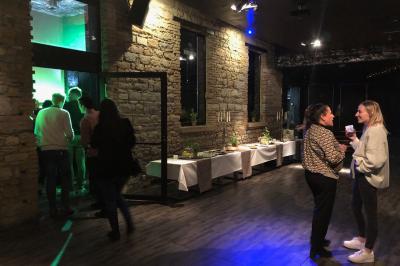 Parking extérieur de nuit, éclairé par des lumières jaunes et entouré d'arbres et de bâtiments.