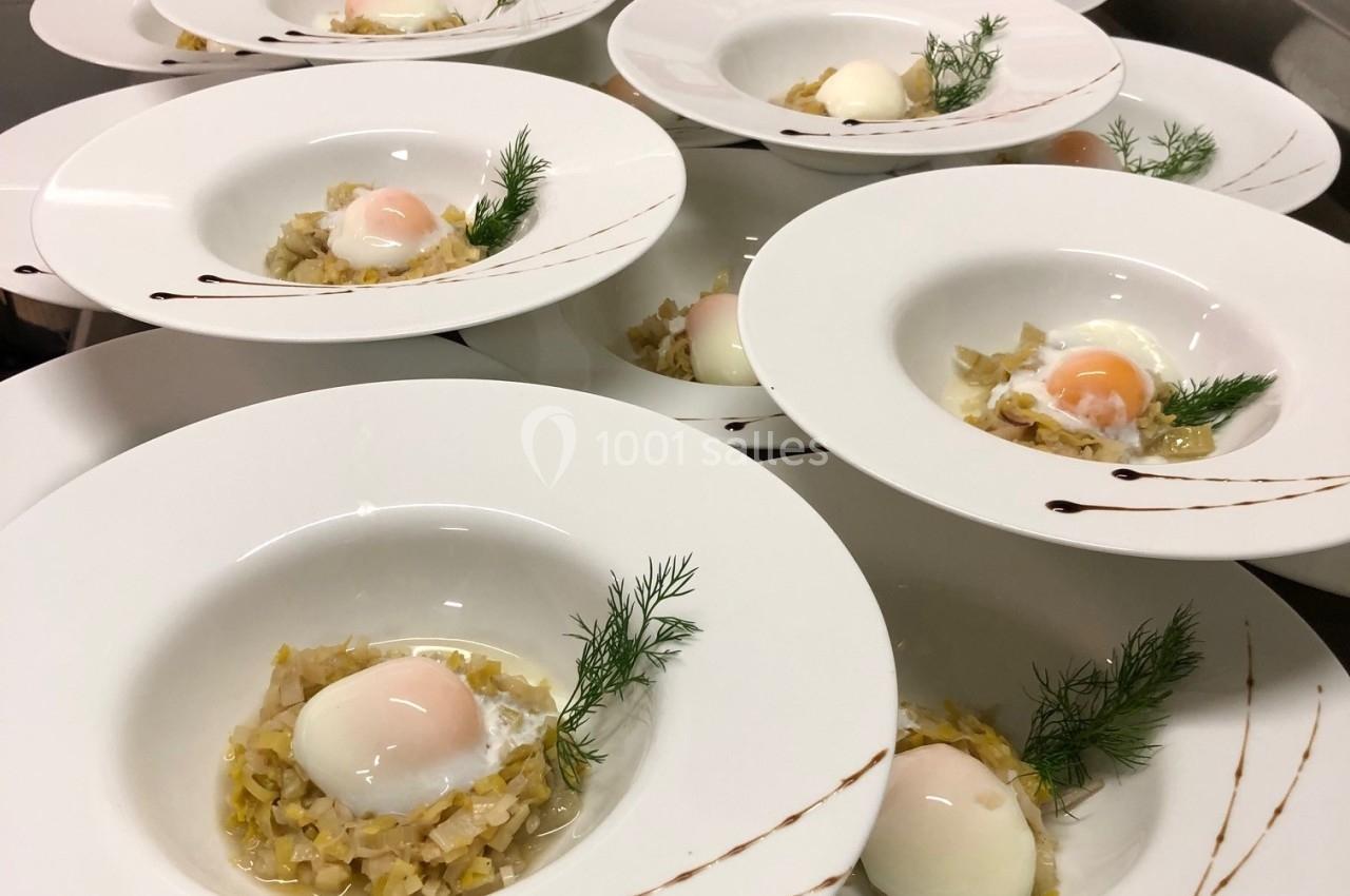 Assiettes dressées avec des œufs pochés sur un lit de légumes, décorées de brins d'aneth et de traits de sauce.