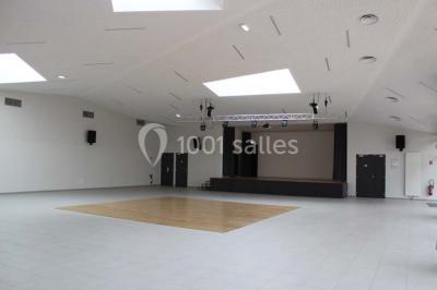 Cuisine professionnelle avec plans de travail en inox, équipements de cuisson, éviers et carrelage mural gris.